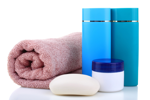 Bathroom toiletries including a pink towel, a white soap bar, a cream jar, and two blue bottles.